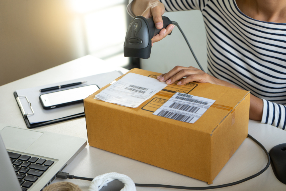 a woman scans a barcode on a cardboard