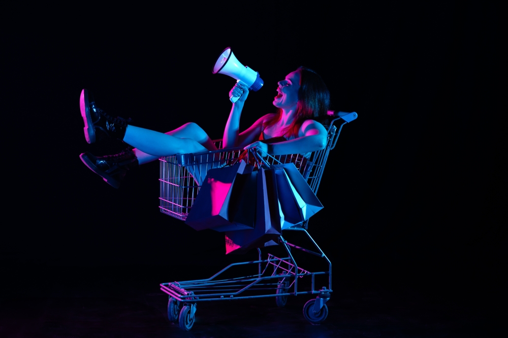 woman in shopping cart with megaphone