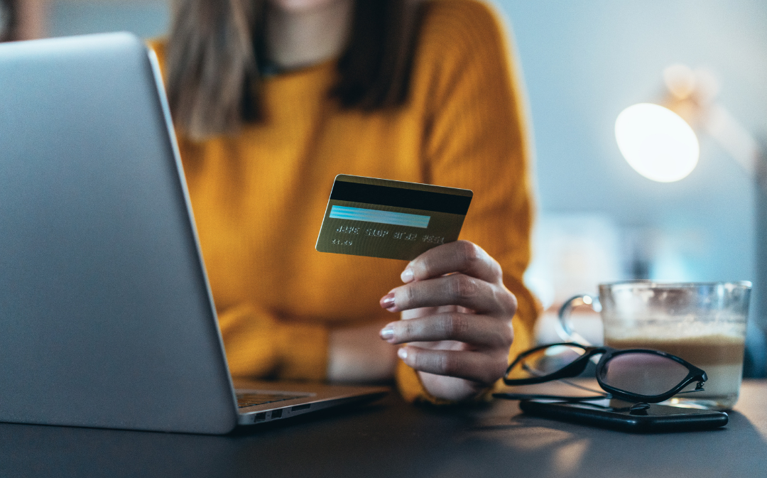 personne avec ordinateur et carte bancaire